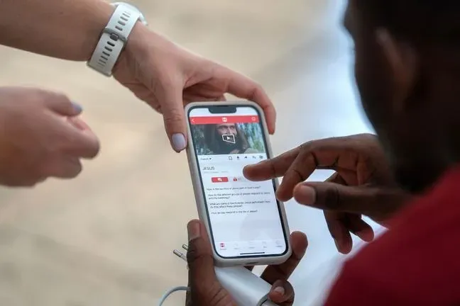 People using the Jesus Film mobile app on a phone.